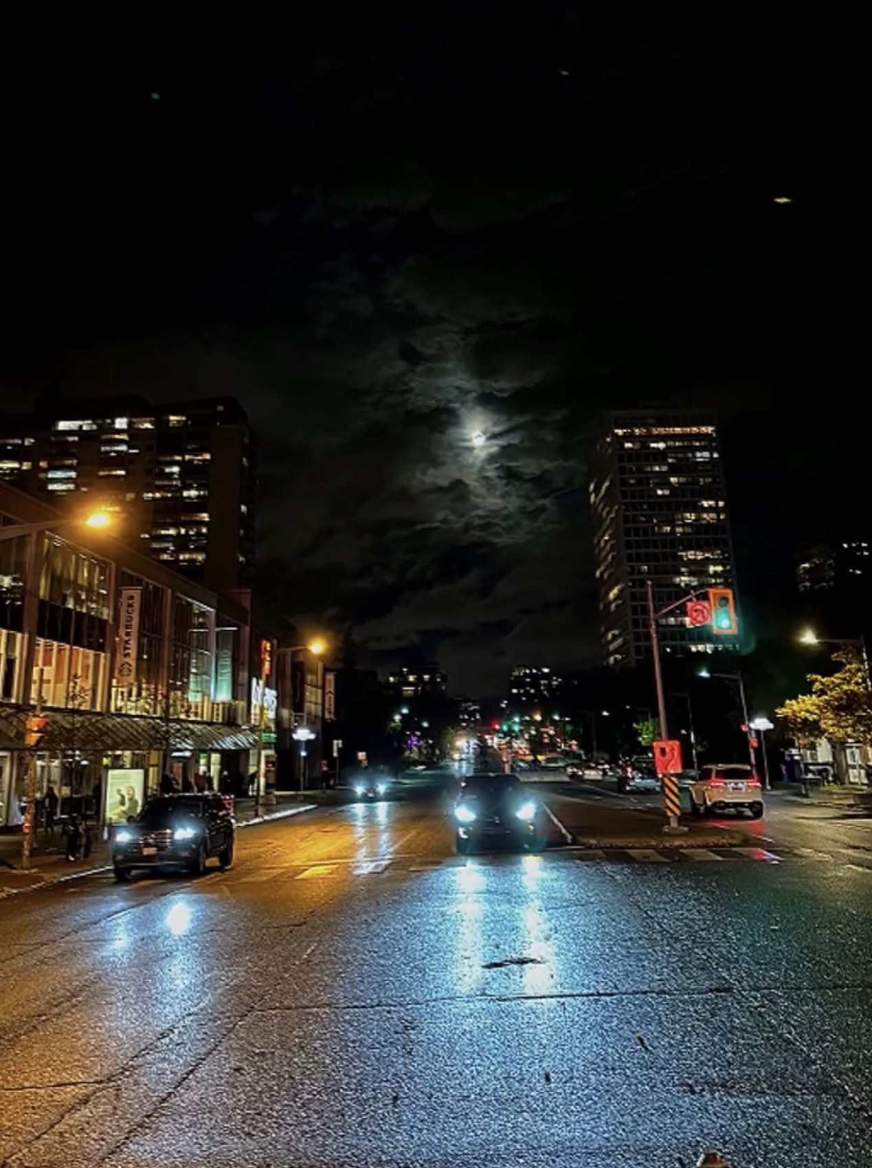 Toronto street at night with full moon breaking through clouds